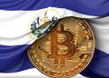 Picture of a gold bitcoin with El Salvador flag half draped over it